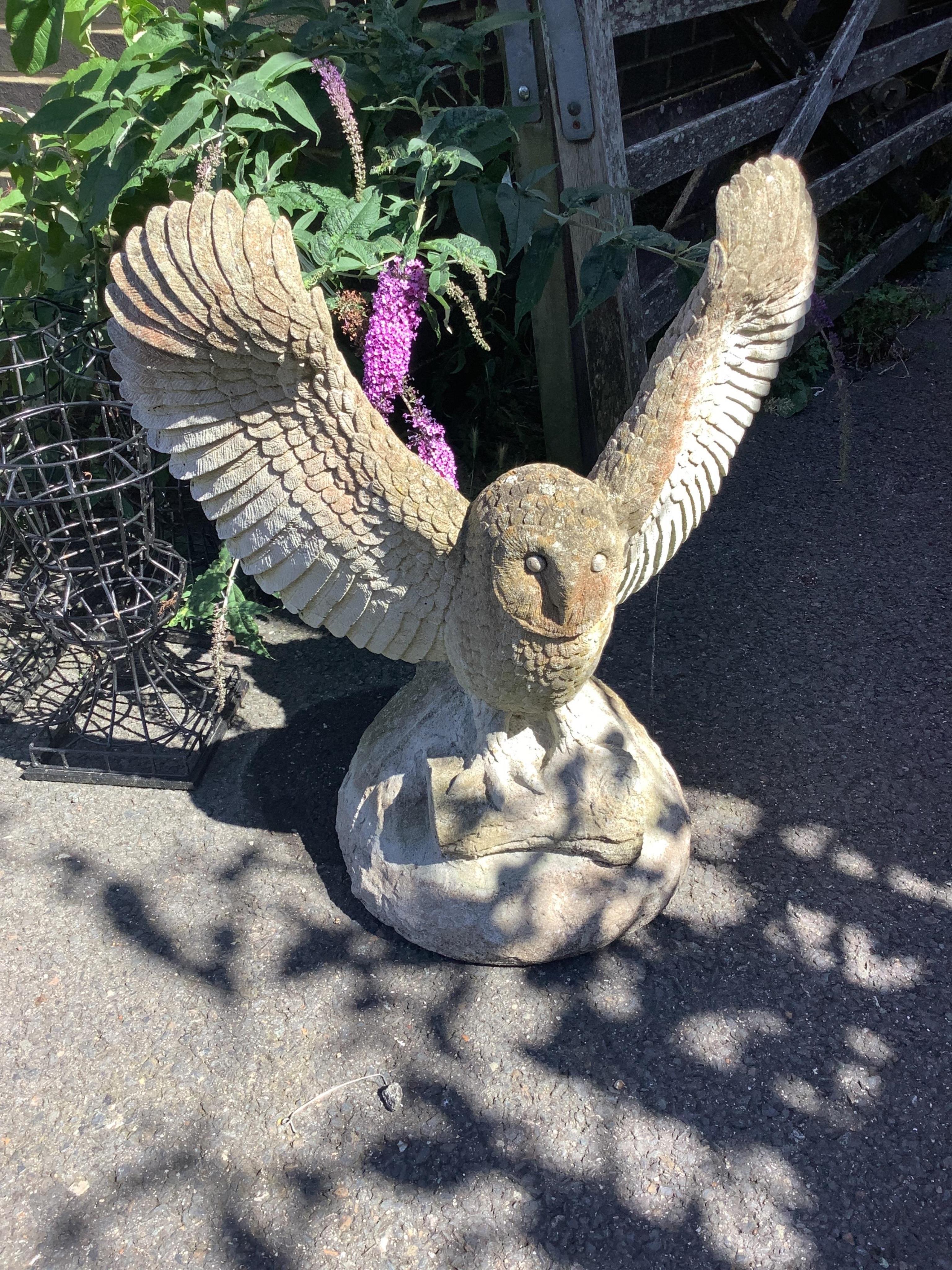 A reconstituted stone owl garden ornament, width 61cm, height 71cm. Condition - fair